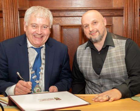 Cathaoirleach of Donegal County Council Martin Harley signing the Distinguished Visitors Book with Mick Coleman of the Finn Valley Vikings on the occasion of their Civic Reception